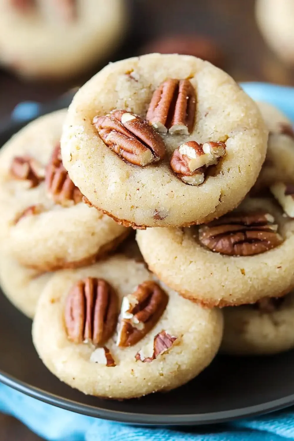 Close-up of Homemade Pecan Sandies cookies with whole pecans pressed into the center of each cookie.