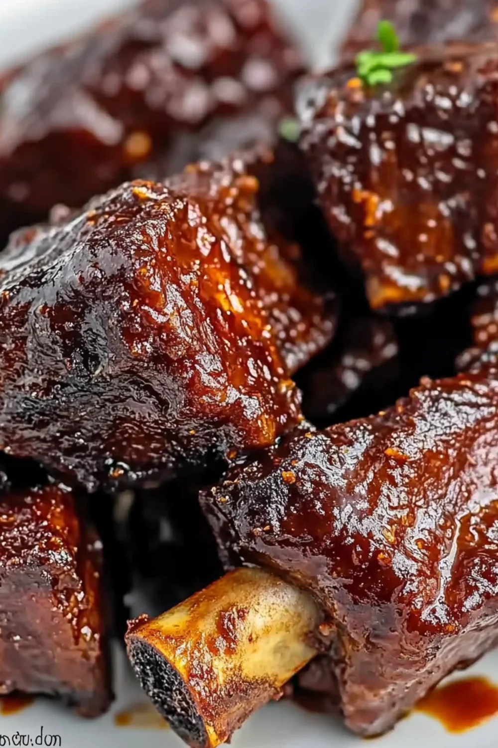 Close-up of juicy, glazed boneless country-style ribs coated in thick, sticky barbecue sauce.