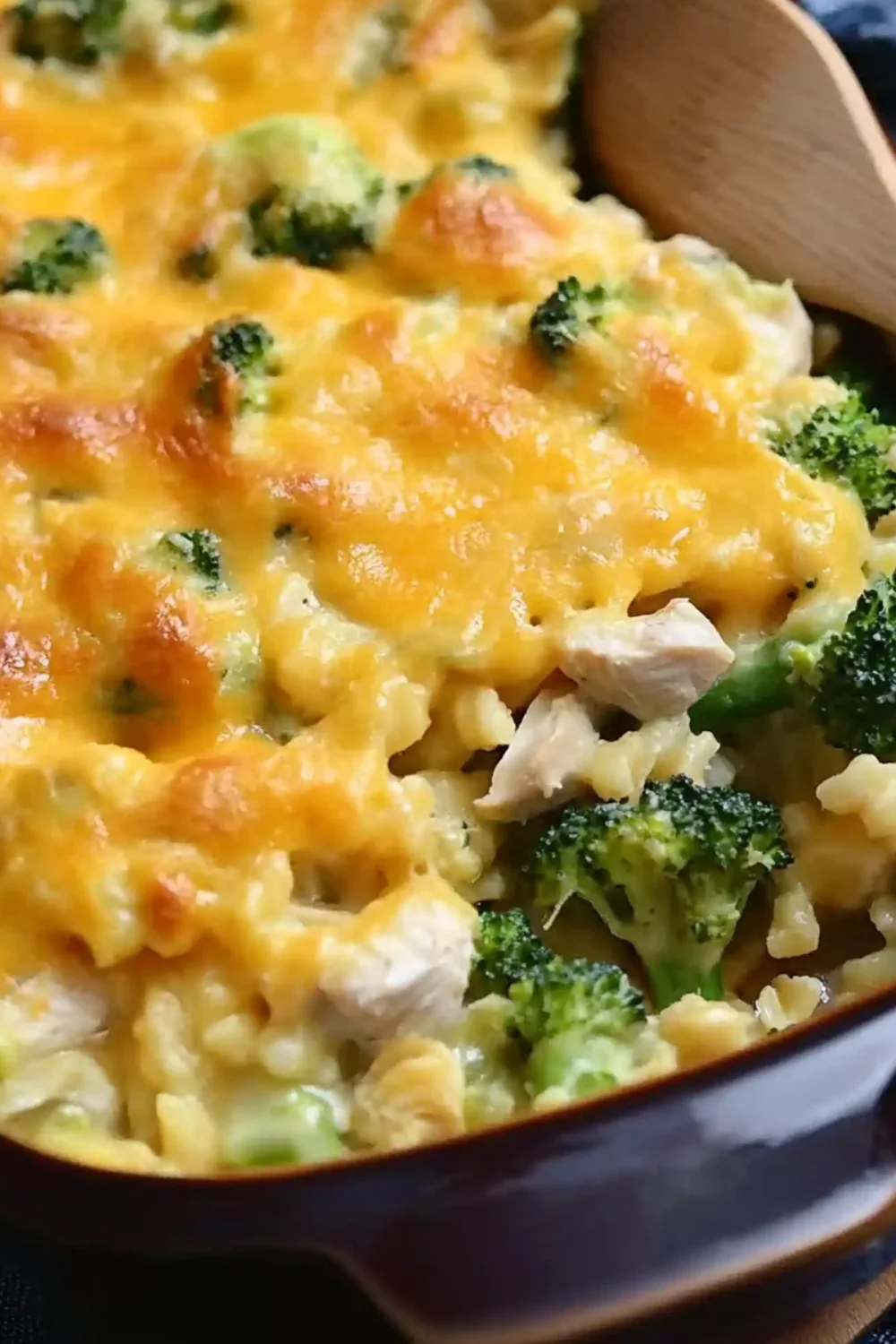 Cheesy baked chicken and broccoli casserole with golden melted cheese on top, served in a ceramic dish.